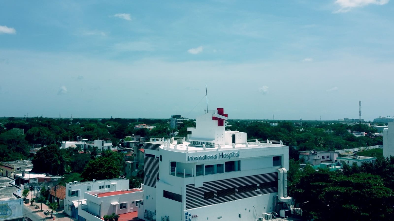 El Hospital Internacional visto desde el aire, con la cruz roja sobre la azotea y la isla alrededor.
