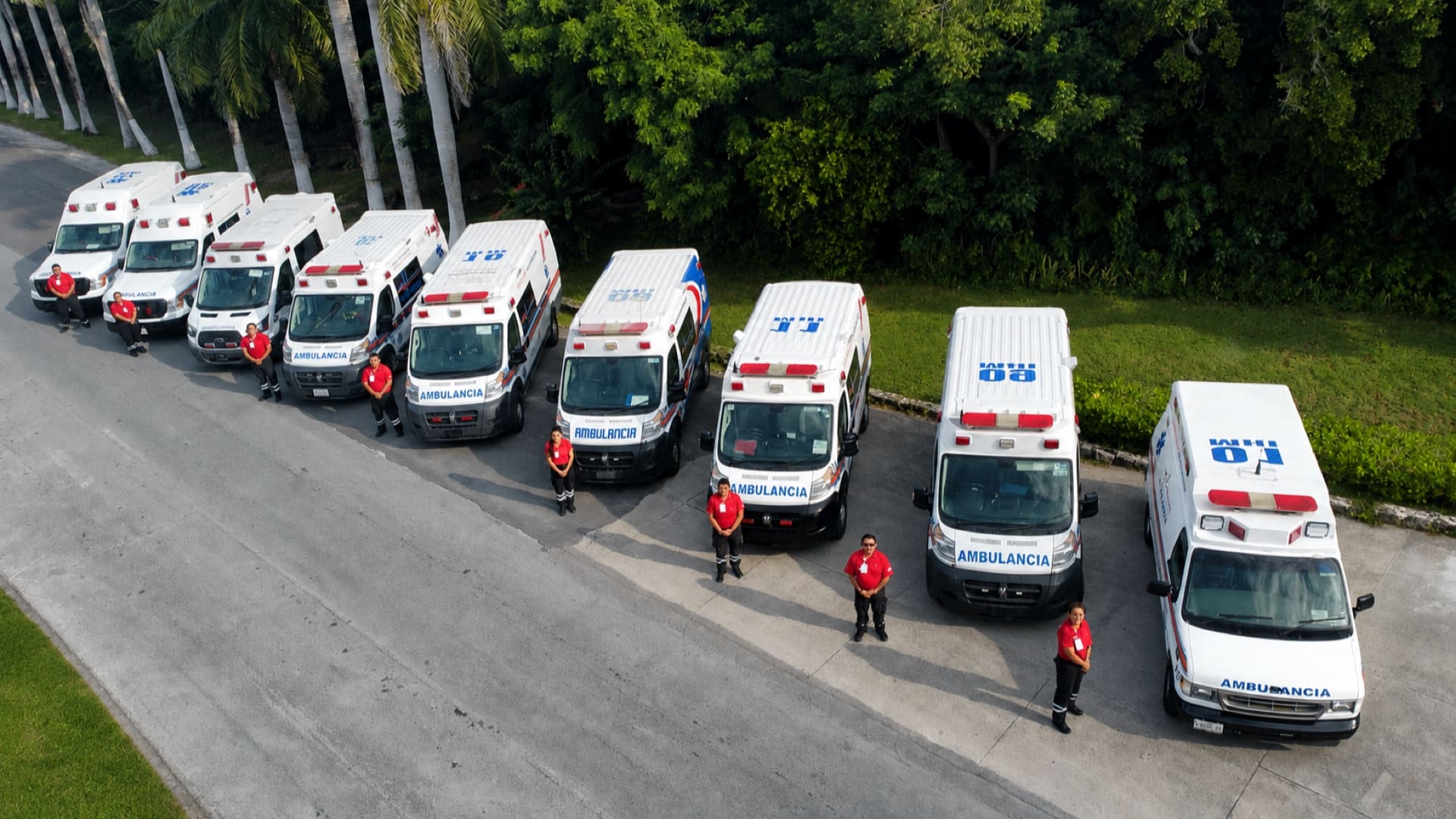 La flota de ambulancias del Hospital Internacional formada, con un paramédico junto a cada unidad.